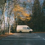 Car park that was lay by tarmac contractors bordered with trees and a van parked in a space